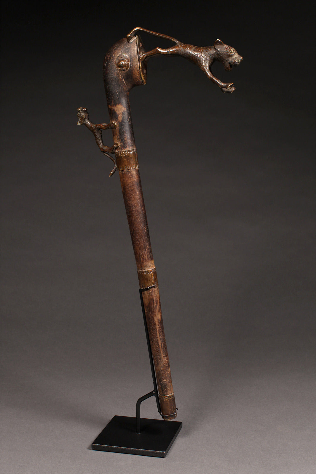 Tribal Objects - African Tribal Art - Ancient Ceremonial Art - Handcrafted Artifacts - Masks - Wood Sculptures - Iron Bronze Objects - Textiles - Art Pieces - African Folk Art - This Zoomorphic Prestige Staff Scepter is a stunning piece of African art. Carved by the Fon tribe of Republic of Benin, this scepter is made of wood, bronze, and brass. Highly sought after by collectors, this artifact is an exquisite example of tribal sculptures. Height: 23" Inventory # 10393