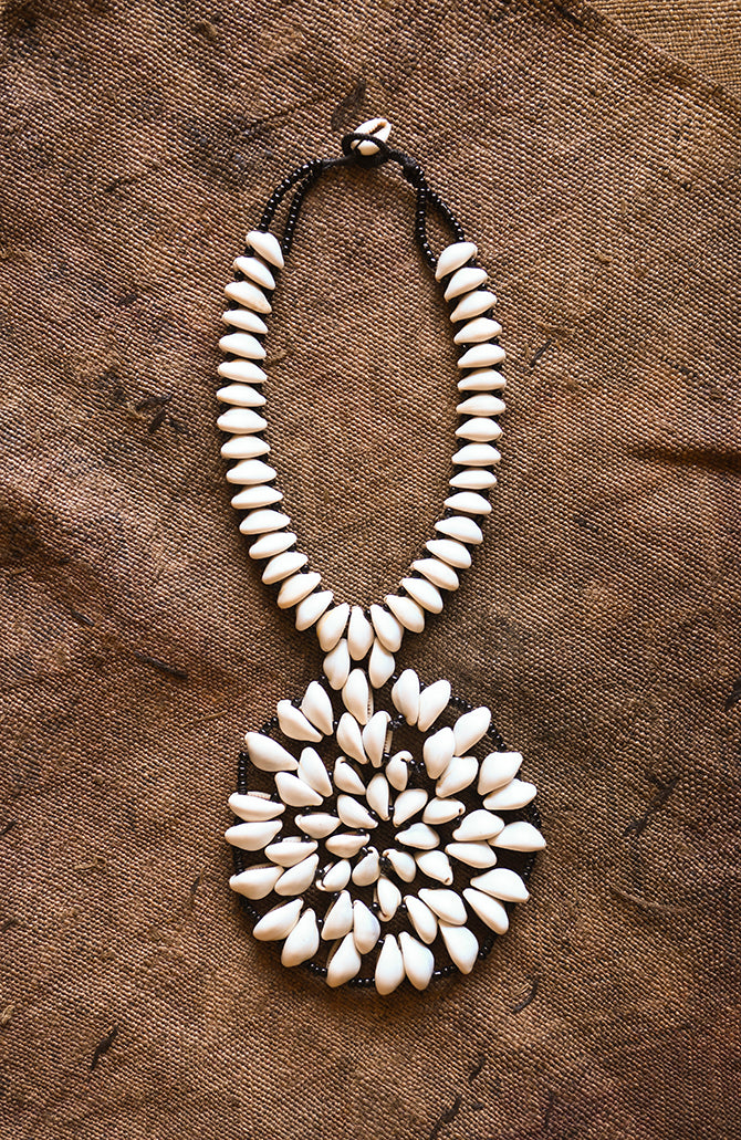 Handcrafted Necklaces - Handmade - African Art - Jewelry - Beaded Necklaces - This Statement African Jewelry Necklace is handmade and features an authentic Cowrie Shell Beads Pendant. Its intricate design adds to any look, making it a classic and chic closet staple. Length: 14 inches Inventory # 10831