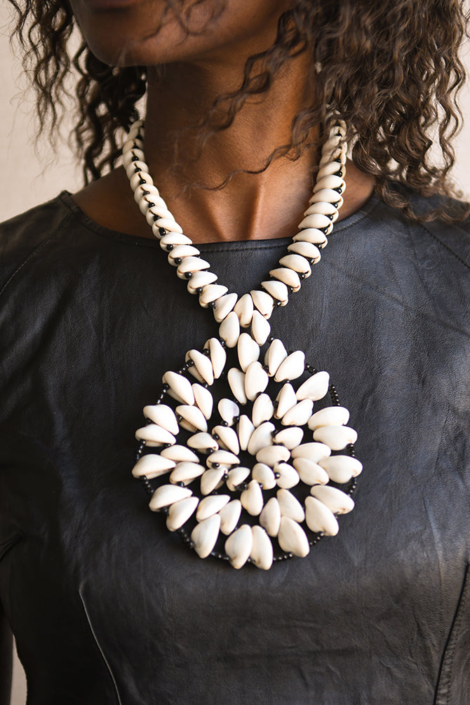 Handcrafted Necklaces - Handmade - African Art - Jewelry - Beaded Necklaces - This Statement African Jewelry Necklace is handmade and features an authentic Cowrie Shell Beads Pendant. Its intricate design adds to any look, making it a classic and chic closet staple. Length: 14 inches Inventory # 10831