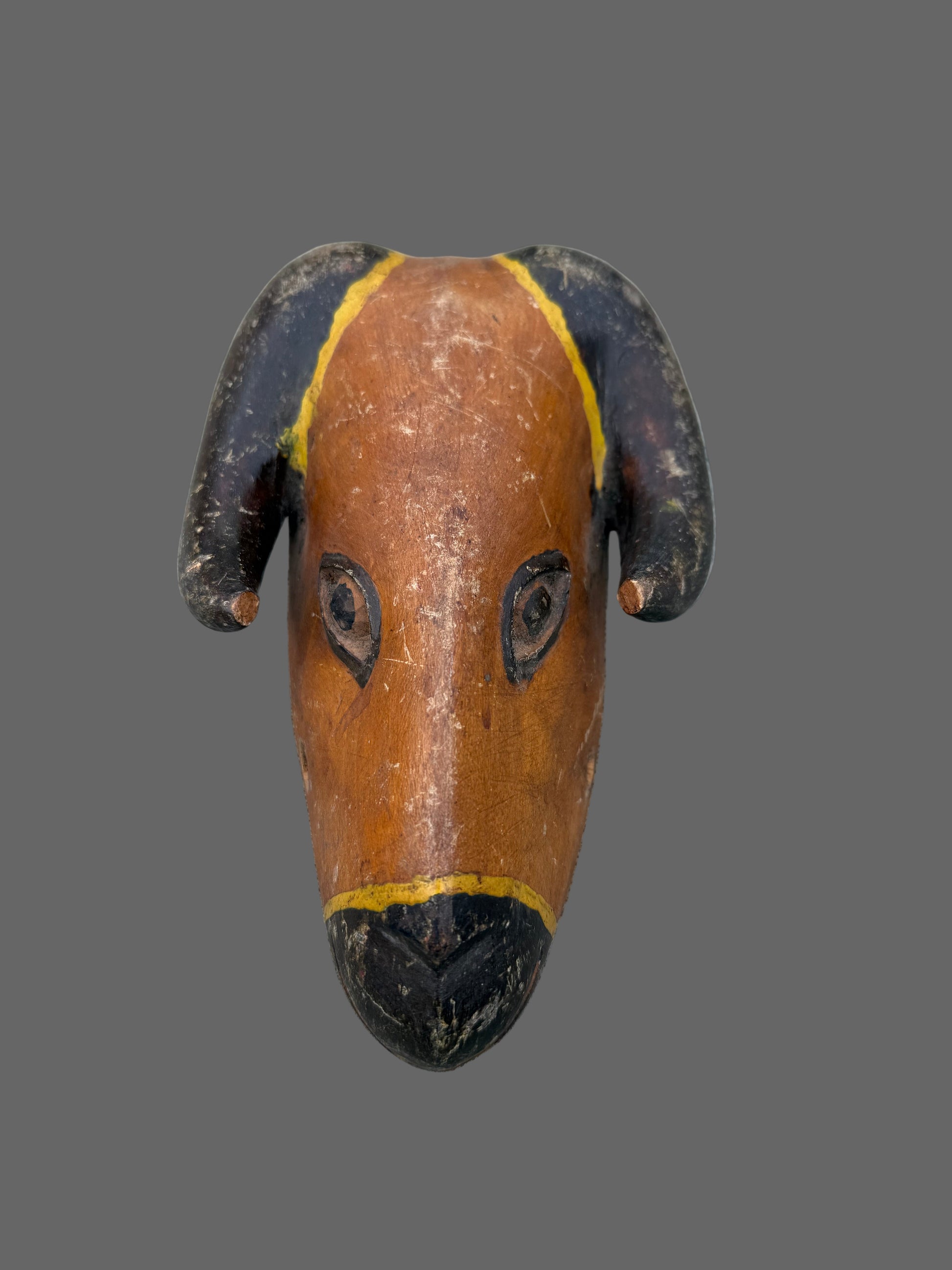 Wooden figure of a ram on a gray surface