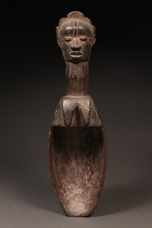 Tribal Objects - African Tribal Art - Ancient Ceremonial Art - Handcrafted Artifacts - Masks - Wood Sculptures - Iron Bronze Objects - Textiles - Art Pieces - African Folk Art - This authentic Ceremonial Ladle Spoon from the Dan Tribe in Liberia, Ivory Coast is carved from wood and features unique figures and artifacts. An ideal piece for collectors, the spoon is a great way to commemorate traditional culture. 22" x 6.25" Inventory # 10308