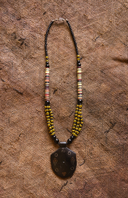 Handcrafted Necklaces - Handmade - African Art - Jewelry - Beaded Necklaces - This Tribal Beaded Jewelry Necklace is handmade from African vintage chevron trade beads, assembling a unique and exotic tribal style. Each bold pendant complements the look and feel of its wooden base, creating a timeless piece for any occasion. Length: 13" Inventory # 10852