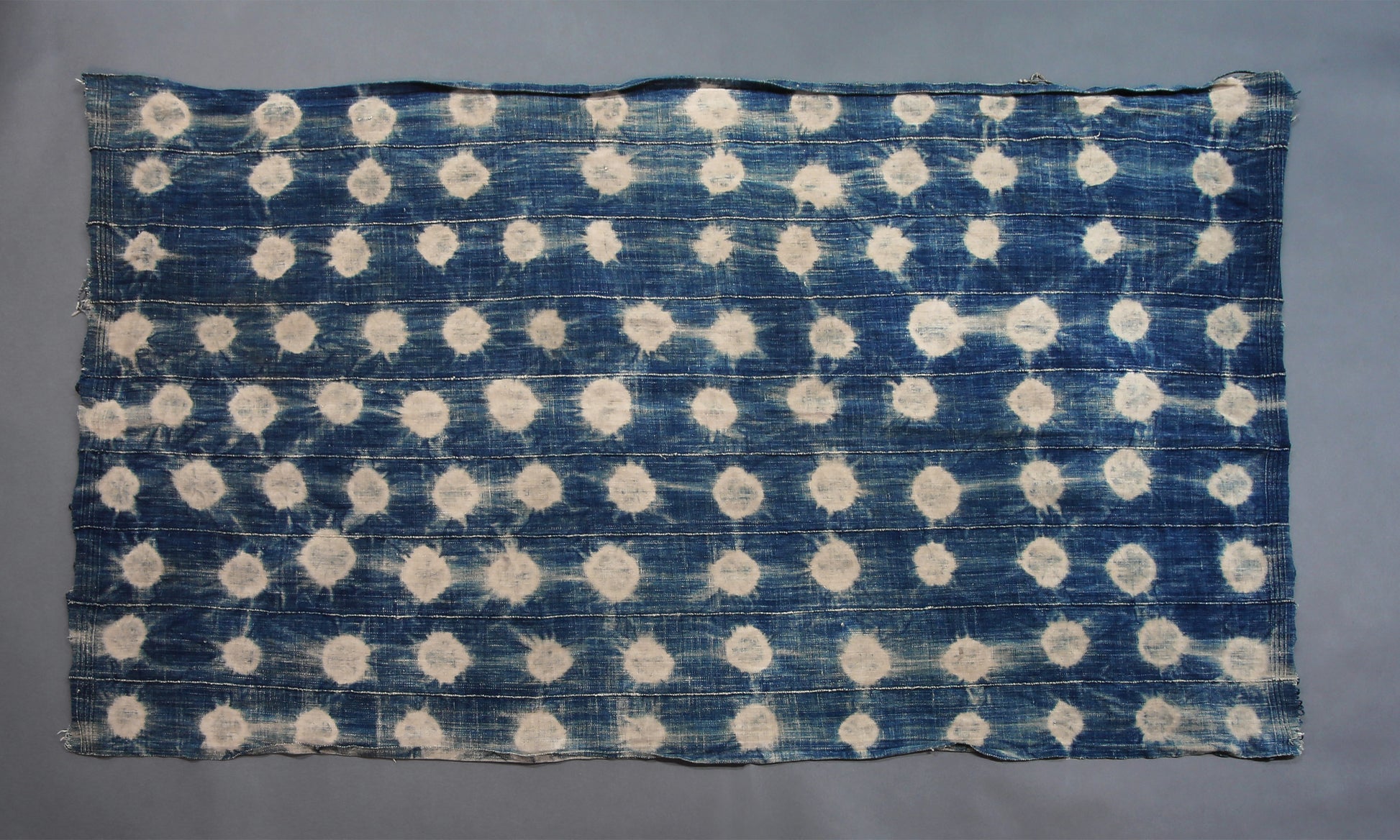 Handcrafted Textiles - Artisan Designed - Handcrafted African Art Textiles - Home Decor - Living Spaces - Mix Colors - Bold Patterns - Traditional Designs - African Culture - This Faded Indigo Scarf Tie Dye Fabric is a vintage African textile shawl that combines a signature faded blue hue with classic tie dye pattern. Crafted from high-quality fabric, this shawl is sure to bring a timeless style to your wardrobe. 60" X 32" Inventory # 10821