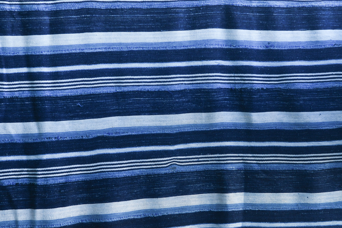 Handcrafted Textiles - Artisan Designed - Handcrafted African Art Textiles - Home Decor - Living Spaces - Mix Colors - Bold Patterns - Traditional Designs - African Culture - This Striped Textile is constructed from Vintage African Cotton material and is distinguished by its Indigo Dyed design. As a home decor accent, it adds a sophisticated yet bold touch to any living space. Length: 62 inches Width: 43 inches