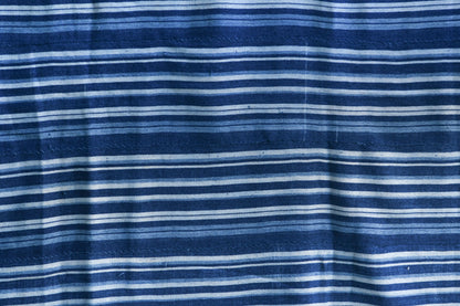 Handcrafted Textiles - Artisan Designed - Handcrafted African Art Textiles - Home Decor - Living Spaces - Mix Colors - Bold Patterns - Traditional Designs - African Culture - Add a unique piece to your home decor with this Indigo Dyed Stripe Woven Textile. This vintage faded blue cotton fabric is an authentic African Mossi textile, perfect for making a statement in any living space. Crafted with premium detail and care, it is suitable for both everyday use and collections. Length: 61 inches Width: 42 inches